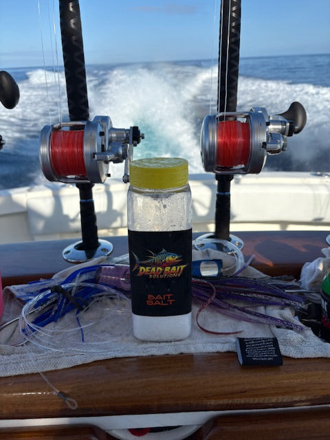 Fishing equipment with a bottle of bait salt on a boat deck.